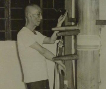 A Wing Chun practitioner demonstrating Gaun Sao on the wooden dummy